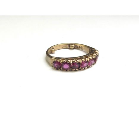 A 9ct gold seven stone ruby ring. Size K with spacers, 2.8g 