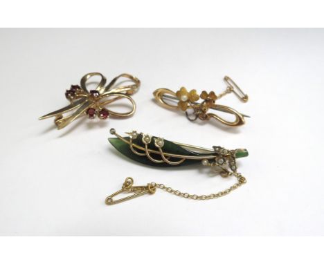 A 9ct gold bow brooch, 5.3g, a 15ct gold bar brooch, 2.8g and a 9ct gold framed jade brooch with applied gold and seed pearl 