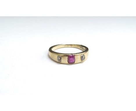 A gold ruby and diamond three stone ring, in rub over setting, marks rubbed 18ct. Size L, 4g 