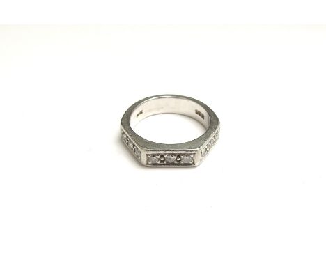 A white metal ring set with a row of diamonds in canted shoulders. Size K/L, 8.5g 