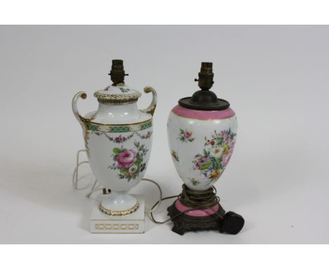 A 19th century two handled ceramic lamp, decorated with sprays of flowers, with a gilded finish, along with one other