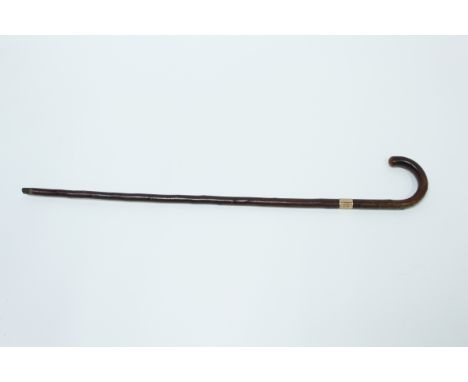 A wooden walking stick, with 9 carat gold band