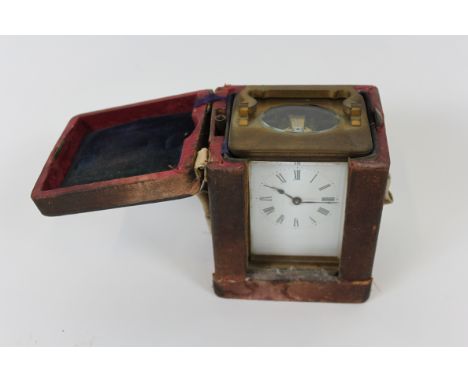 A 20th century French carriage clock with a white enamel dial and Roman numerals, in a fitted leather case