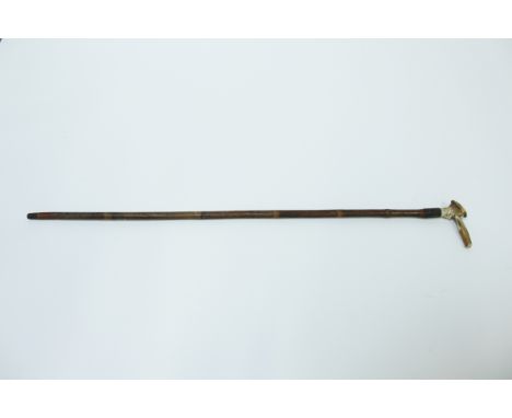 A bamboo walking stick, the handle carved with a comical face 