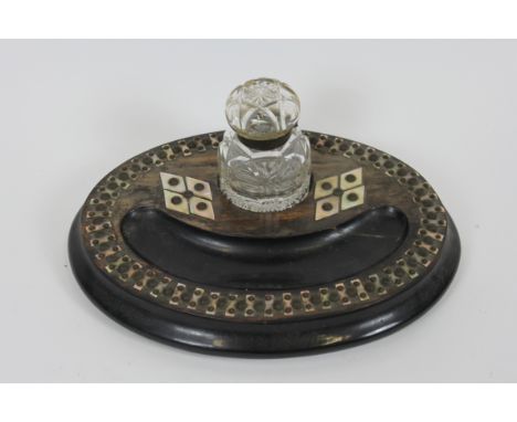A Victorian ebony, with mother of pearl and metal studded decoration, with a single glass inkwell