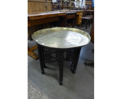 An eastern carved hardwood and brass topped occasional table 