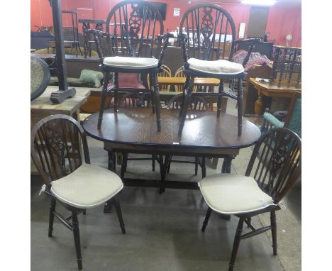 An oak extending dining table and six beech wheelback chairs 