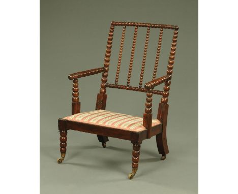 A 19th century bobbin turned chair, with striped and floral upholstered seat, the legs on brass castors.  Width 64 cm, height