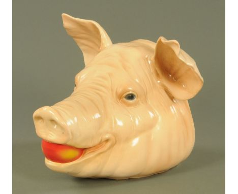 A large Goebel pottery pigs head, 20th century, modelled with an apple its mouth, printed marks, 29 cm high, 34 cm at widest 