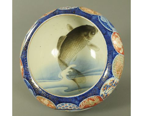 A Japanese Imari carp bowl, Meiji period, the interior decorated with a large carp leaping out of water, the exterior with pa