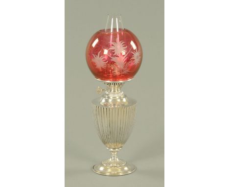 A silver plated oil lamp, late 19th/early 20th century, having an etched cranberry glass shade upon a reeded vase shaped body