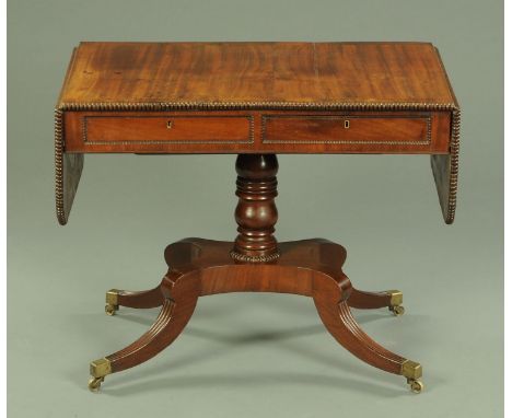 A Regency mahogany rosewood crossbanded sofa table, with half round beaded moulded edge, fitted with two frieze drawers and t