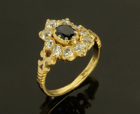 An 18 ct yellow gold sapphire and ring, with central sapphire framed by 10 diamonds. size M.