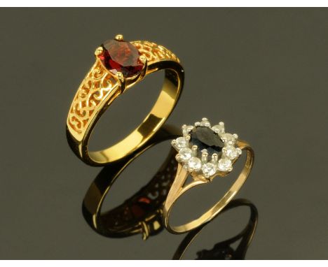 A 9 ct gold dress ring, set with central sapphire framed by pastes, and a gold coloured metal ring set with ruby coloured sto