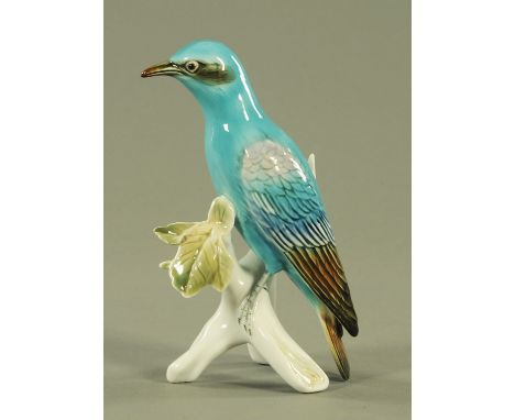 A Karl Ens porcelain model of a roller bird, perched on a leafy branch.  21 cm high.  CONDITION REPORT: This item appears to 