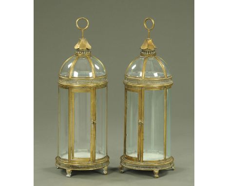 A pair of gilt metal and glass domed lanterns, supported upon short feet, with ring handles.  Height 79.5 cm.