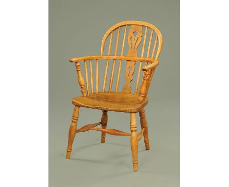 A 19th century light elm and ash comb back Windsor chair, with pierced central splat above a dished seat, all upon turned leg