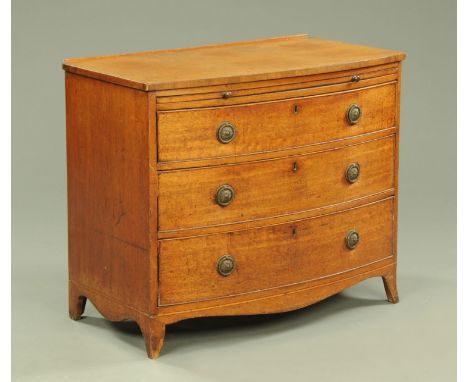 A 19th century mahogany bowfronted chest of drawers, with slide above three drawers with brass drop handles and circular back