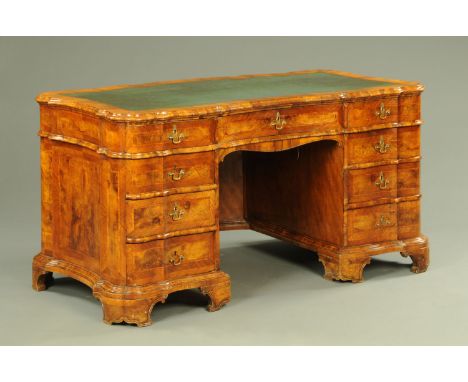 A late 19th century walnut veneered desk, of serpentine form, with green gilt tooled leather writing surface and fitted with 