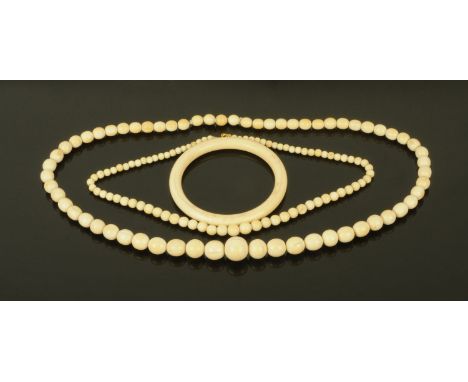 Two ivory beaded necklaces and an ivory bangle, early 20th century.  Bangle interior diameter 7.5 cm. 