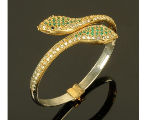 A snake bangle, set with green, blue and clear stones and with sprung mechanism.