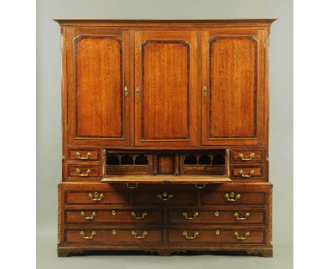 A good North Counties oak and mahogany crossbanded secretaire cupboard, the three panelled doors with applied moulding, each 