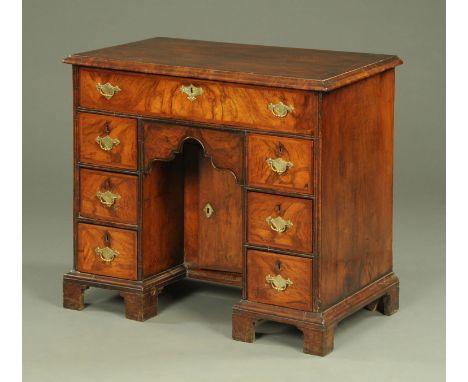 A George III walnut kneehole desk, with crossbanded moulded edge above a frieze drawer, kneehole recess with cupboard and thr