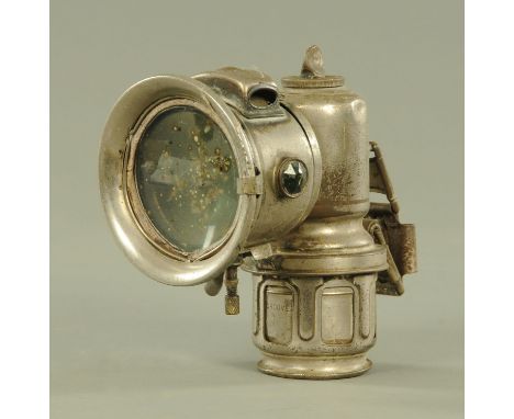 A Lucas "Calcia Major" nickel finish carbide motorcycle headlamp, with faceted green prisms to the sides.  Height 17 cm.