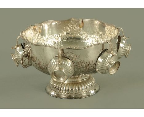 A silver plate on copper punch bowl, with gadrooned rim, lion mask and ring handles and embossed floral swags, all on a raise