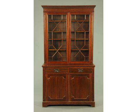 An Edwardian mahogany bookcase on cupboard, with astragal glazed doors enclosing adjustable shelves, in turn above two short 