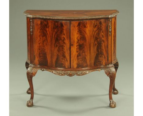 A flame veneered mahogany commode cabinet, with moulded edge above pair of serpentine doors and all raised on carved cabriole