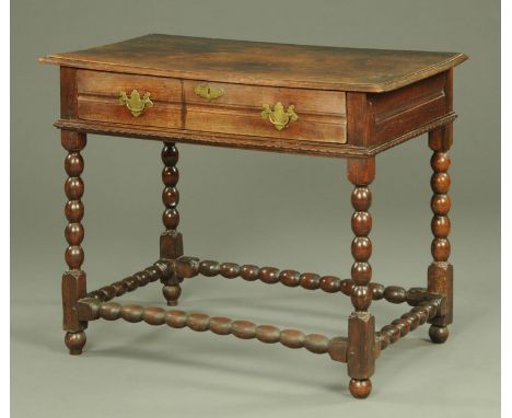 An antique oak side table, with moulded edge and frieze drawer, with bobbin turned supports beneath with low stretchers and s