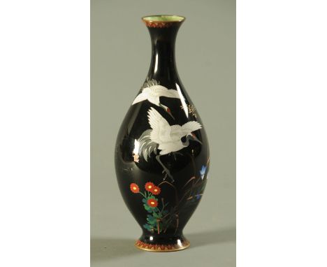 A Japanese cloisonne vase, circa 1900, decorated with two Manchurian cranes in flight above blossoming flowers against a mirr