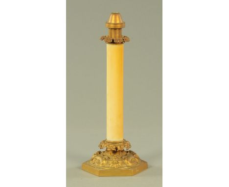 A Victorian candle lamp, with sprung interior, having a plain glass column with foliate capital, the embossed base with folia