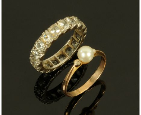 A 9 ct white gold paste set eternity ring, size L/M, and a gold coloured ring set with a pearl, size K. 