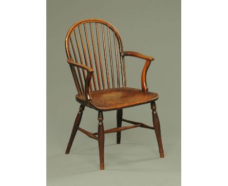 A 19th century ash and elm comb back Windsor armchair, 19th century, upon turned legs united by plain stretchers.  53 cm wide