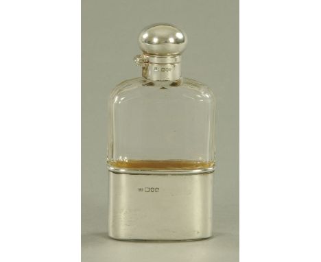 A silver mounted spirit flask, London 1904.  Height 13 cm.  CONDITION REPORT: The gilding on the interior of the silver cup i