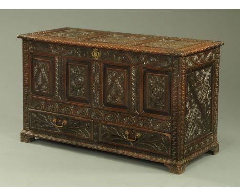 A late 17th century oak coffer, dated 1695, later carved, fitted with two drawers and raised on bracket feet.  Width 132 cm (