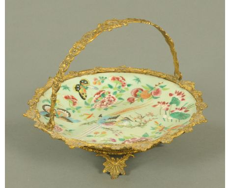 A Chinese Canton porcelain dished plate, 19th century, within gilt metal mounts and with foliate cast handle, decorated with 