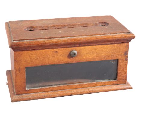 AN EDWARDIAN OAK LETTER BOX with a hinged top and glazed front panel, 18cm high x 36cm wide x 19cm deepProvenance: The Bond F