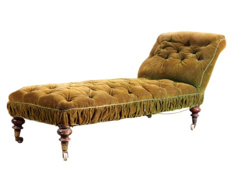 A VICTORIAN CHAISE LONGUE with green velvet buttoned covers, on turned legs terminating in brass toes and ceramic castors, 77