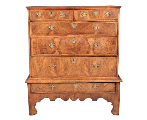 A FIGURED WALNUT CHEST ON STAND 18th century, the moulded top over two short and four long graduated drawers, the lower secti