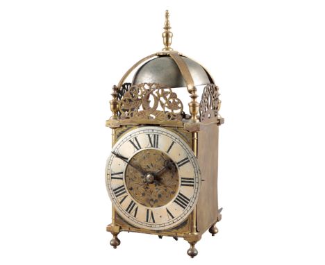 A BRASS LANTERN CLOCK 19th century, the silvered dial with Roman numerals, the case with pierced and carved arches on bun fee