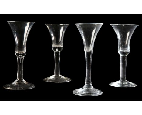 FOUR GEORGIAN WINE GLASSES early 18th century, two with bell-shaped bowls over tear-drop plain stems and folded feet, and two