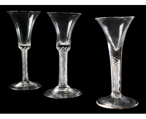 TWO GEORGIAN WINE GLASSES mid-18th century, the bell bowls over air twist stems and folded feet; together with a later contin