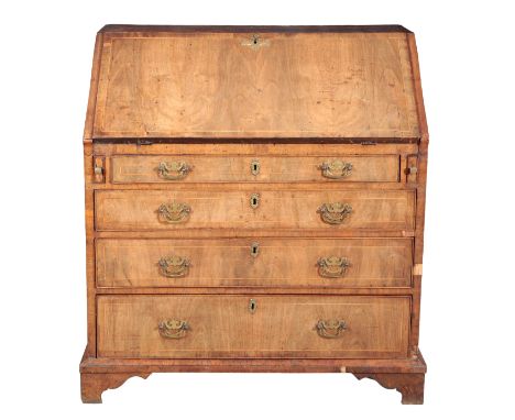 A GEORGE I WALNUT BUREAUthe crossbanded fall front opening to an interior fitted with small drawers and pigeonholes, four gra