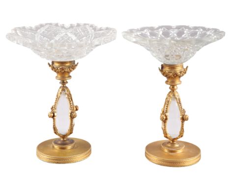 TWO SIMILAR GILT METAL TAZZAS19th/20th century, the cut-glass dishes over  gilt metal baluster columns on beaded and harebell