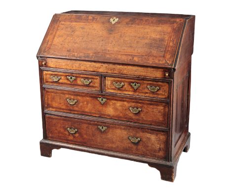 A PROVINCIAL OAK BUREAU18th century, the crossbanded fall front opening to an interior fitted with small drawers and pigeonho