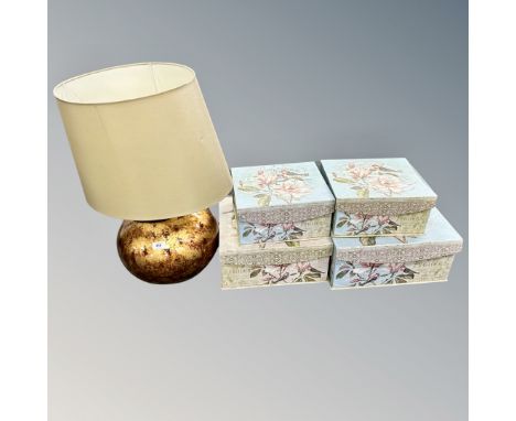 A contemporary copper finished table lamp with shade together with a set of four graduated French style storage boxes 