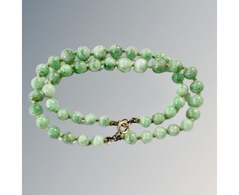A double strand jade bracelet with gold clasp. 